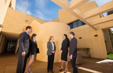 Students in business suits talk on campus - Pepperdine University