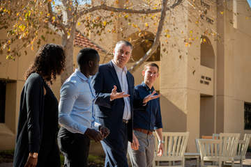 SPP Dean Peterson and students walk on campus