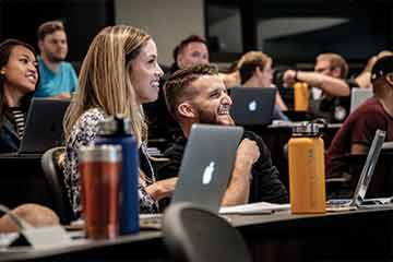 Law students smiling in a lecture hall