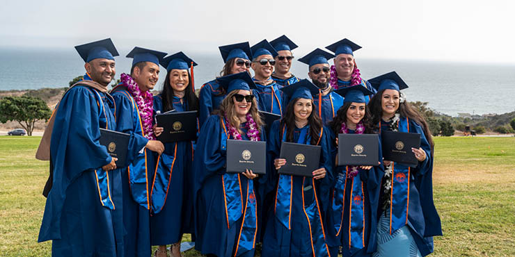 students at graduation with their diplomas