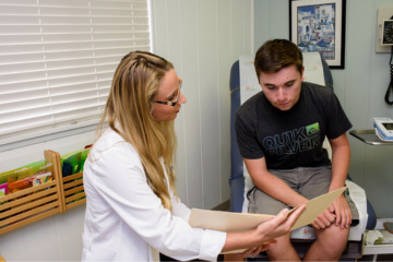 student and medical professional looking at papers