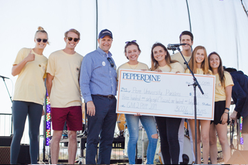 students and president gash receiving donation