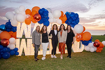 alumni reunion group at the waves weekend light sign