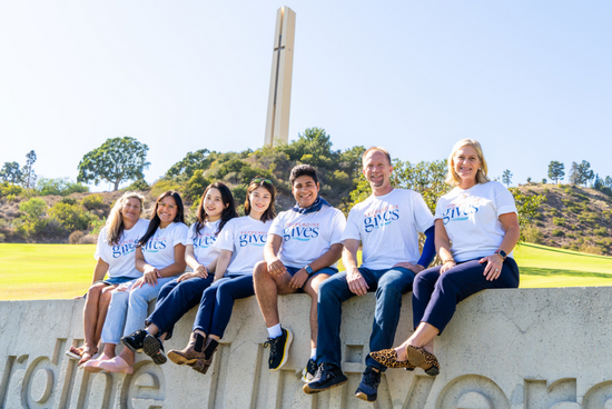 group of staff waving from pepperdine sign