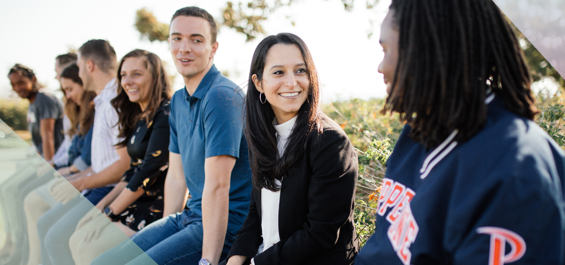 Pepperdine students sitting on sign