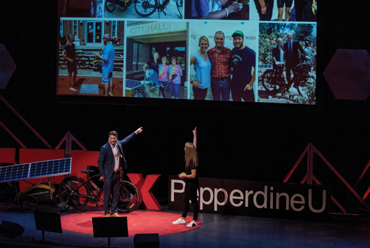 Speakers at this year's TEDxPepperdine event gesture to slides on a screen.