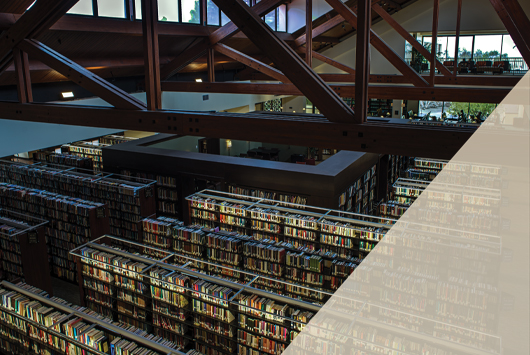 A balcony view of the inside of Payson Library looking down on the stacks of bookshelves.