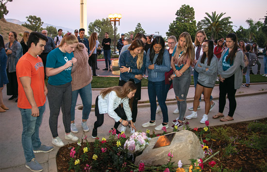 students at memorial dropping flowers