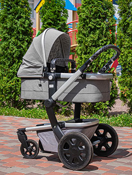 baby carriage/stroller outside by trees at park