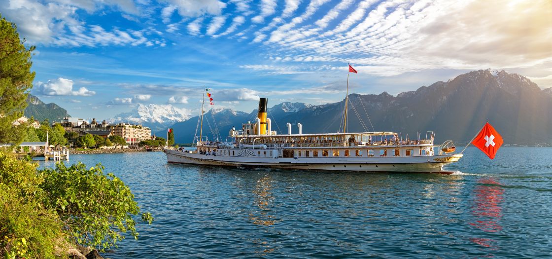warm view of steam boat on lake geneva with swiss flag