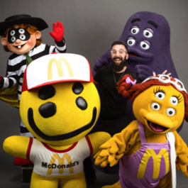Jeffrey Rozman (’11) standing with McDonald's adult happy meal characters