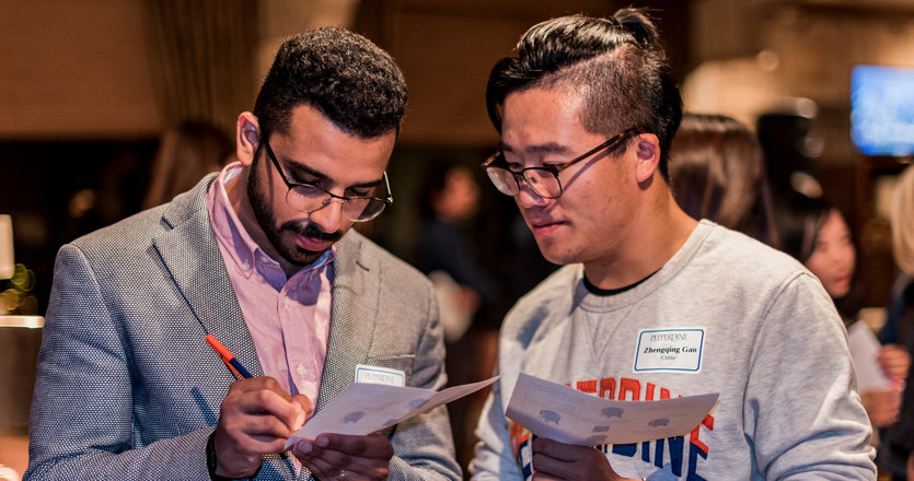 Two international students working looking at a pamphlet