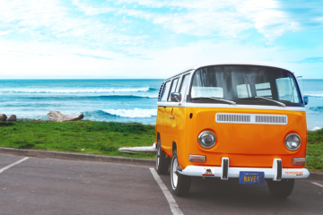 Orange vw bus parked by the ocean