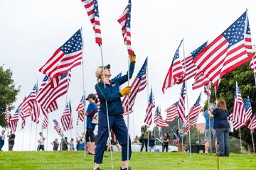 Volunteer standing up flag on Waves of Flags day