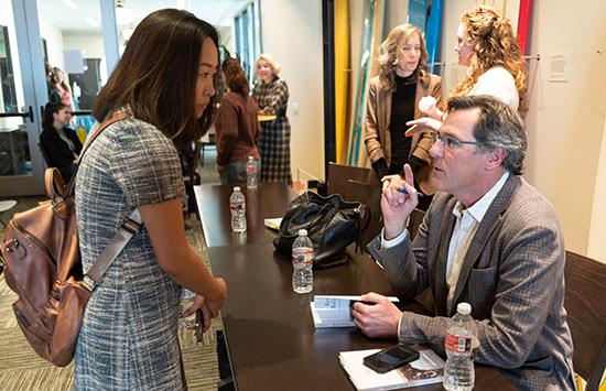 John Barton signing copy of book for attendee