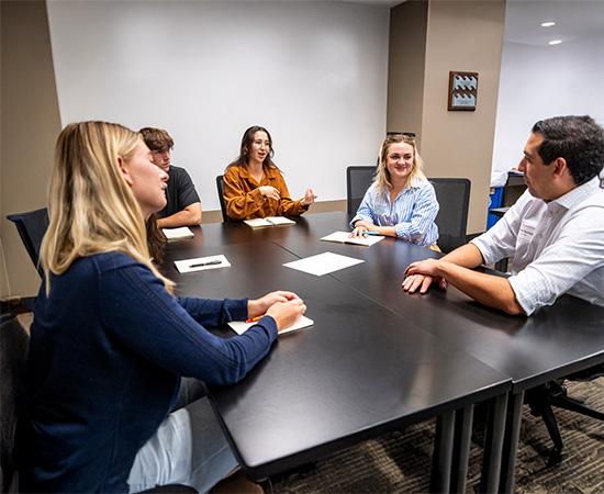 people sitting and talking around a conference table