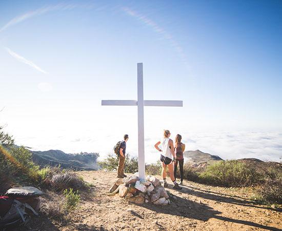 people standing by the Pepperdine cross on top of the mountain