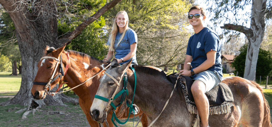 Two students riding horses.