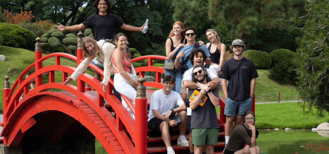 Student gather at Japanese Garden near red bridge.