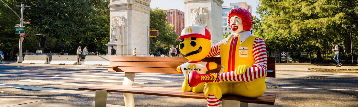 Ronald McDonald sitting beside Cactus Plant Flea Market toy in New York City