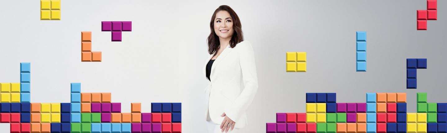 Maya Rogers surrounded by Tetris gaming blocks graphics