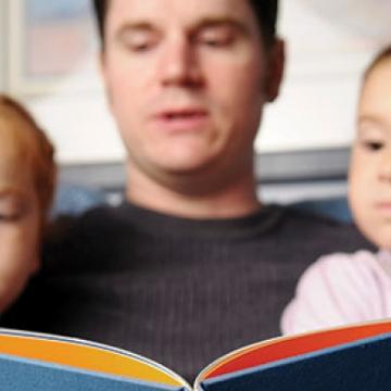 Father reading to children - Pepperdine Magazine