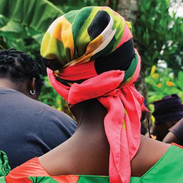 A Ugandan woman wearing a colorful headscarf