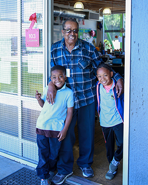 Foster grandparent with two children at their school