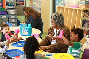 Foster grandparent plays with students