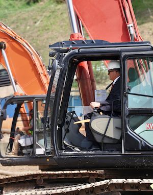 President Jim Gash in bulldozer at the Mountain groundbreaking