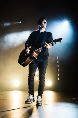 Phil Wickham sings onstage with a guitar