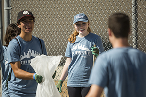 Students clean up trash in the community as part of Step Forward Day