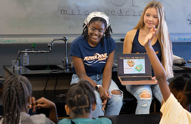 College students showing elementary class scientific topics on a laptop.
