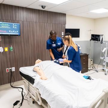 Nursing students work on a patient
