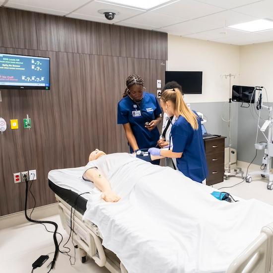 Nursing students work on a patient