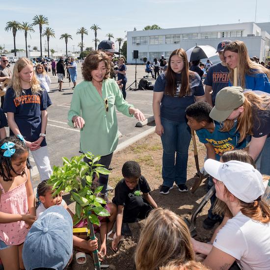 Amy Grant planting a tree with students