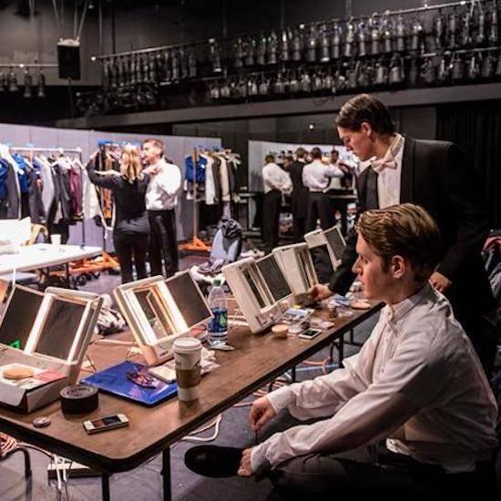 Student-actors backstage at a makeup table