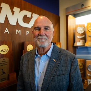 Pepperdine director of athletics Steve Potts in front of Firestone Fieldhouse trophy case.