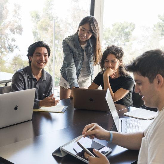 Students studying together around a laptop