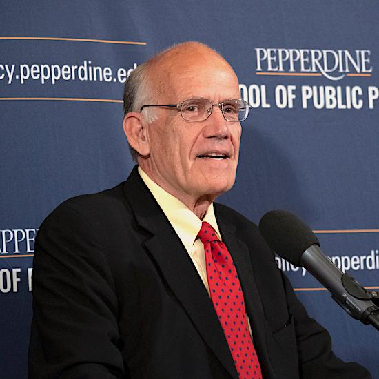 Victor Davis Hanson speaks at a podium at the School of Public Policy