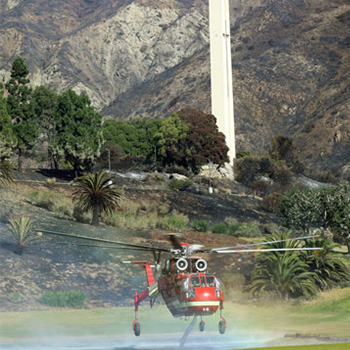 Helicopter grabbing water for fire relief