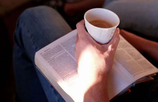 person holding coffee with bible