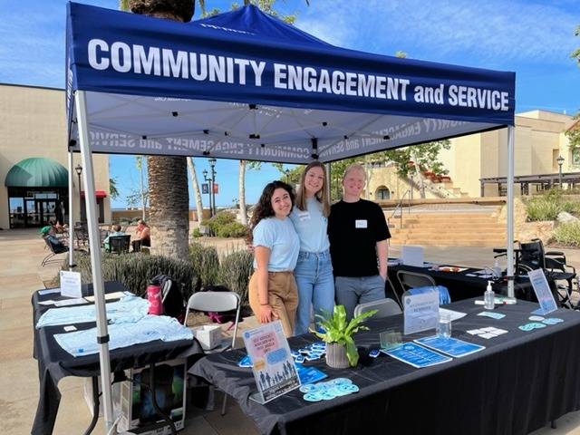 Three volunteers posing at the CES tabling