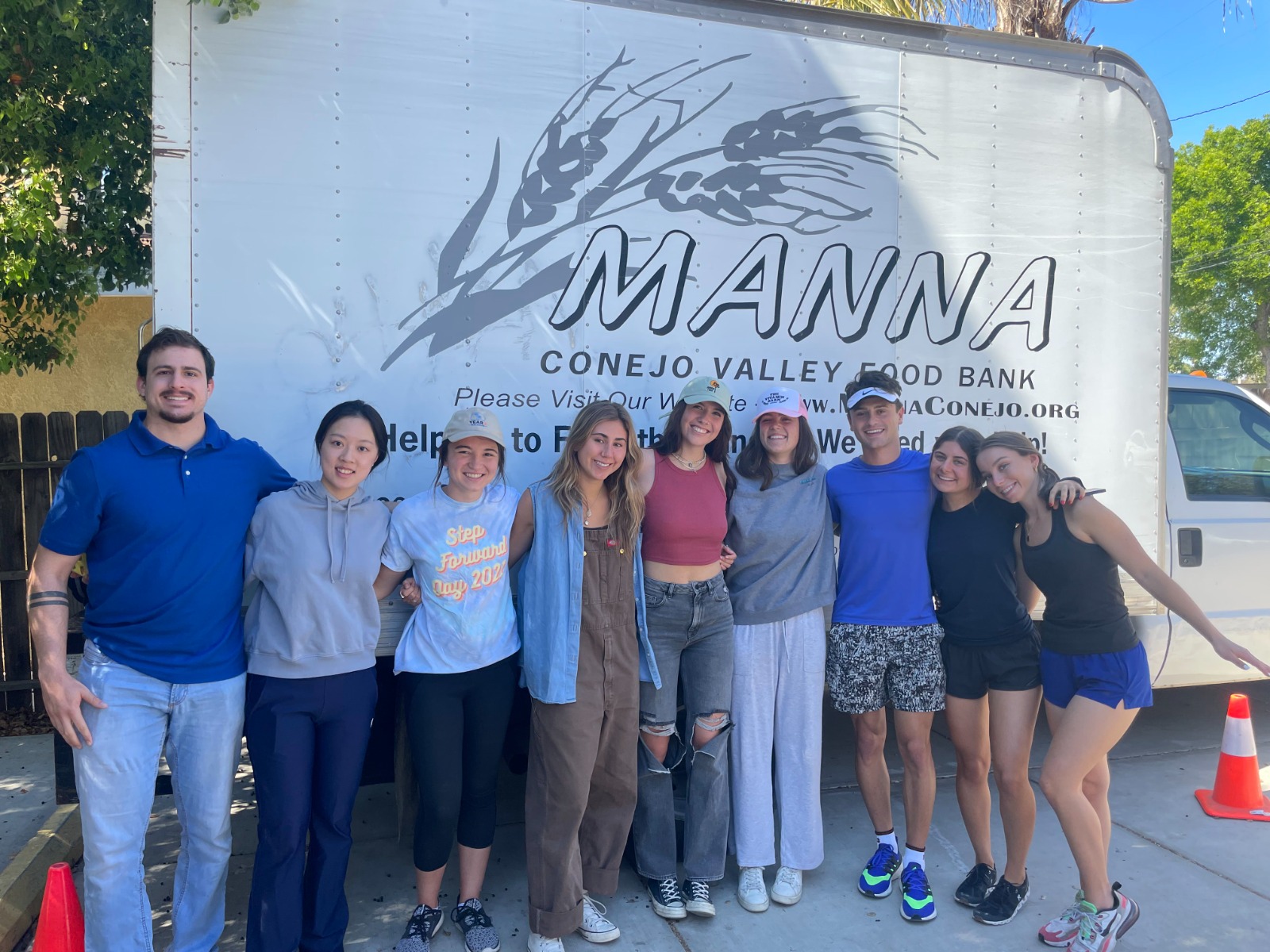 Student volunteers posing in front of Manna Conejo food truck