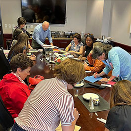 Students participating in a service event, sitting at a table