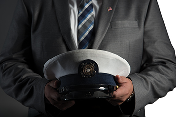 Man dressed in suit holding white hat