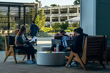 Students working outside on chairs in a circle