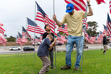 boys inserting flag poles in ground