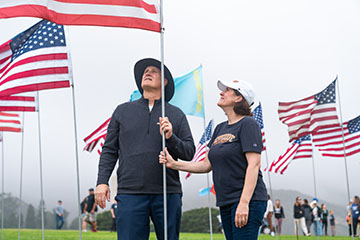 President Gash and wife Joline looking up at flag